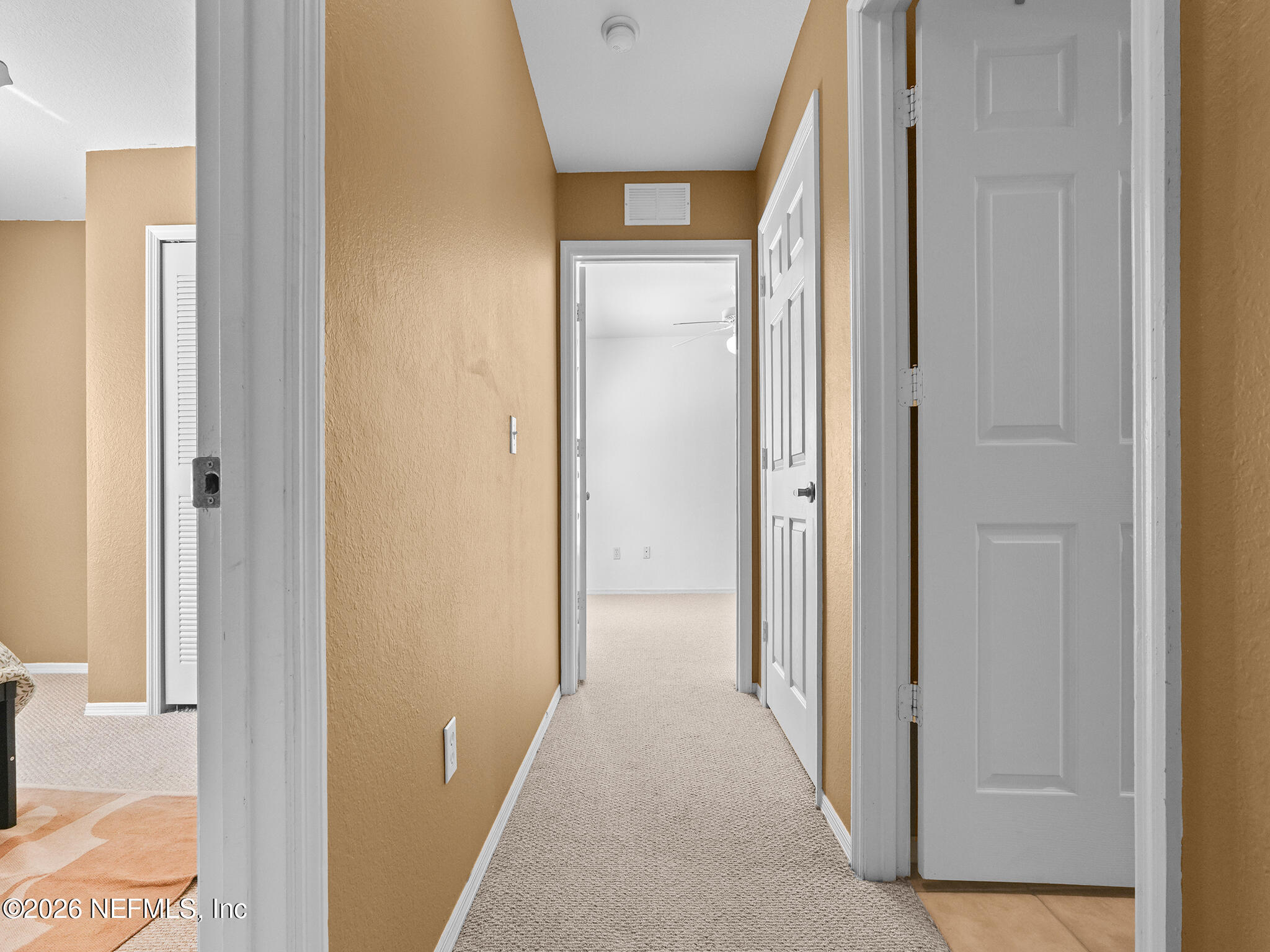 712 Lighthouse Road, Unit 712 Panama City Beach, FL 32407 - Photo 16 of 42 a view of a hallway with wooden floor and a bathroom