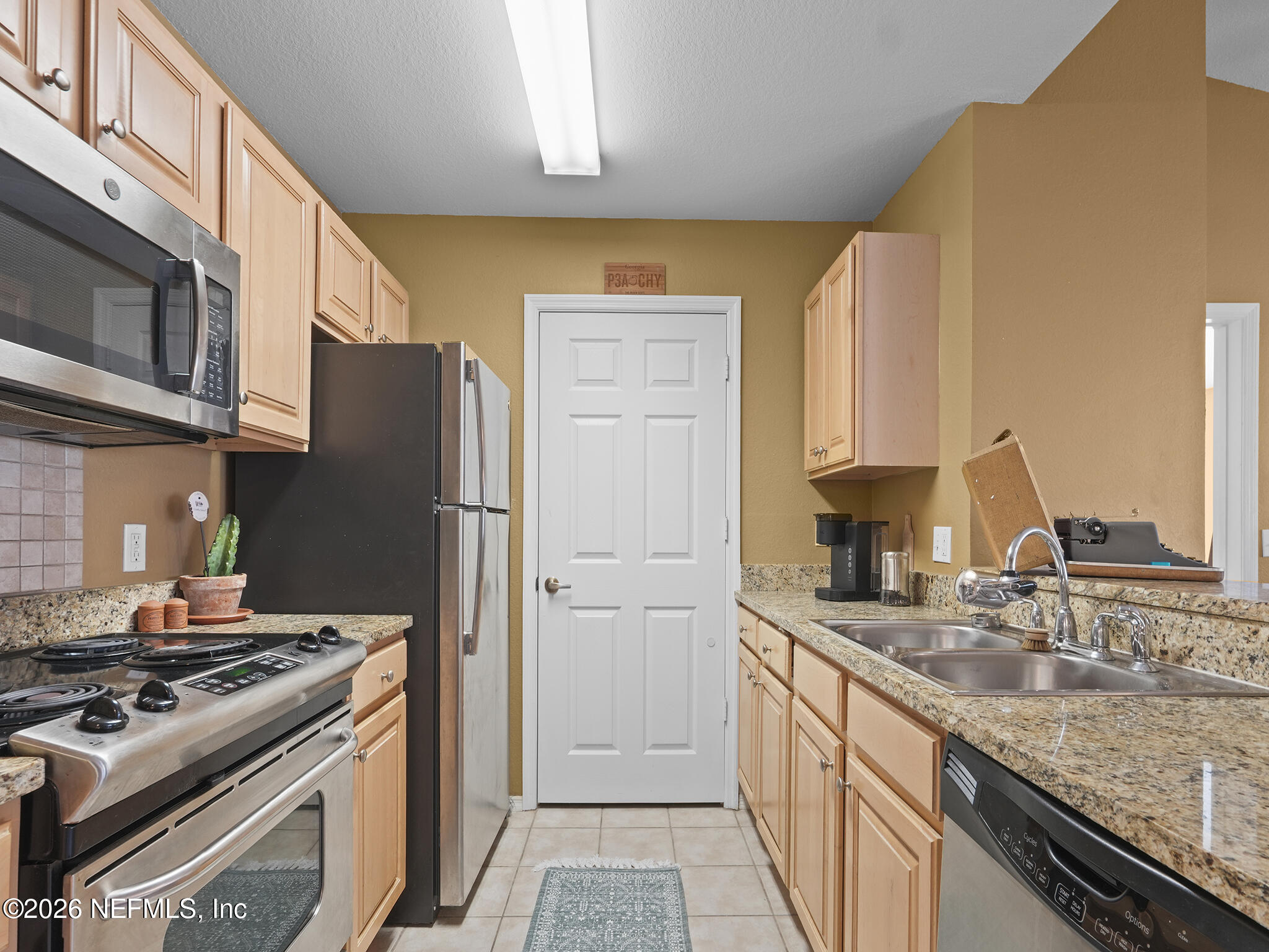 712 Lighthouse Road, Unit 712 Panama City Beach, FL 32407 - Photo 20 of 42 a kitchen with stainless steel appliances granite countertop a sink stove and refrigerator