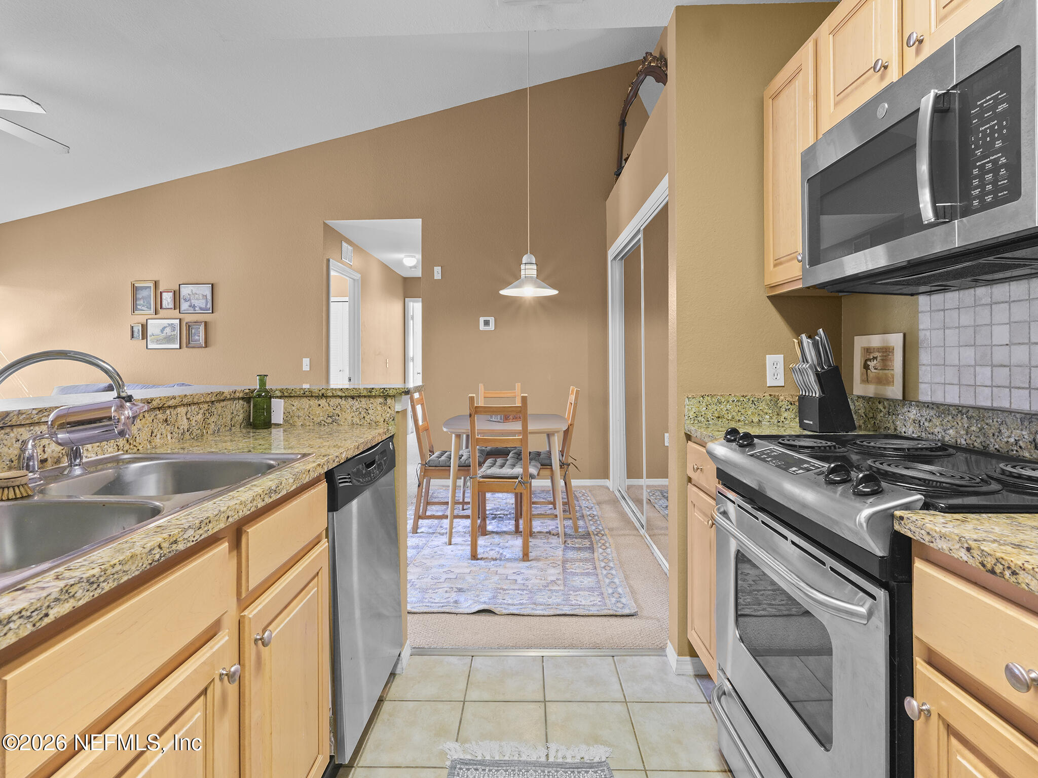 712 Lighthouse Road, Unit 712 Panama City Beach, FL 32407 - Photo 24 of 42 a kitchen with stainless steel appliances granite countertop a stove a sink and a microwave