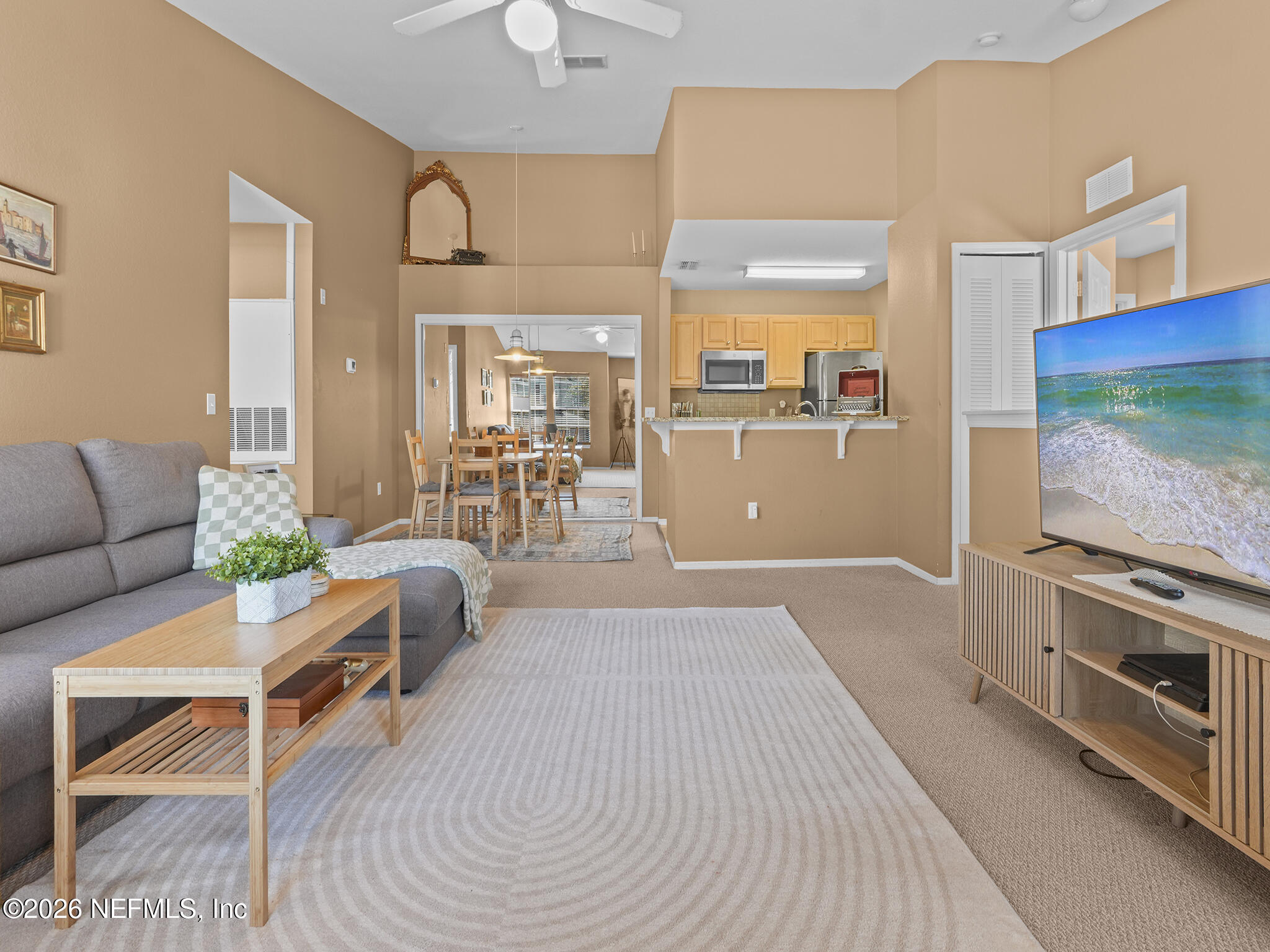 712 Lighthouse Road, Unit 712 Panama City Beach, FL 32407 - Photo 28 of 42 a living room with furniture flat screen tv and a floor to ceiling window