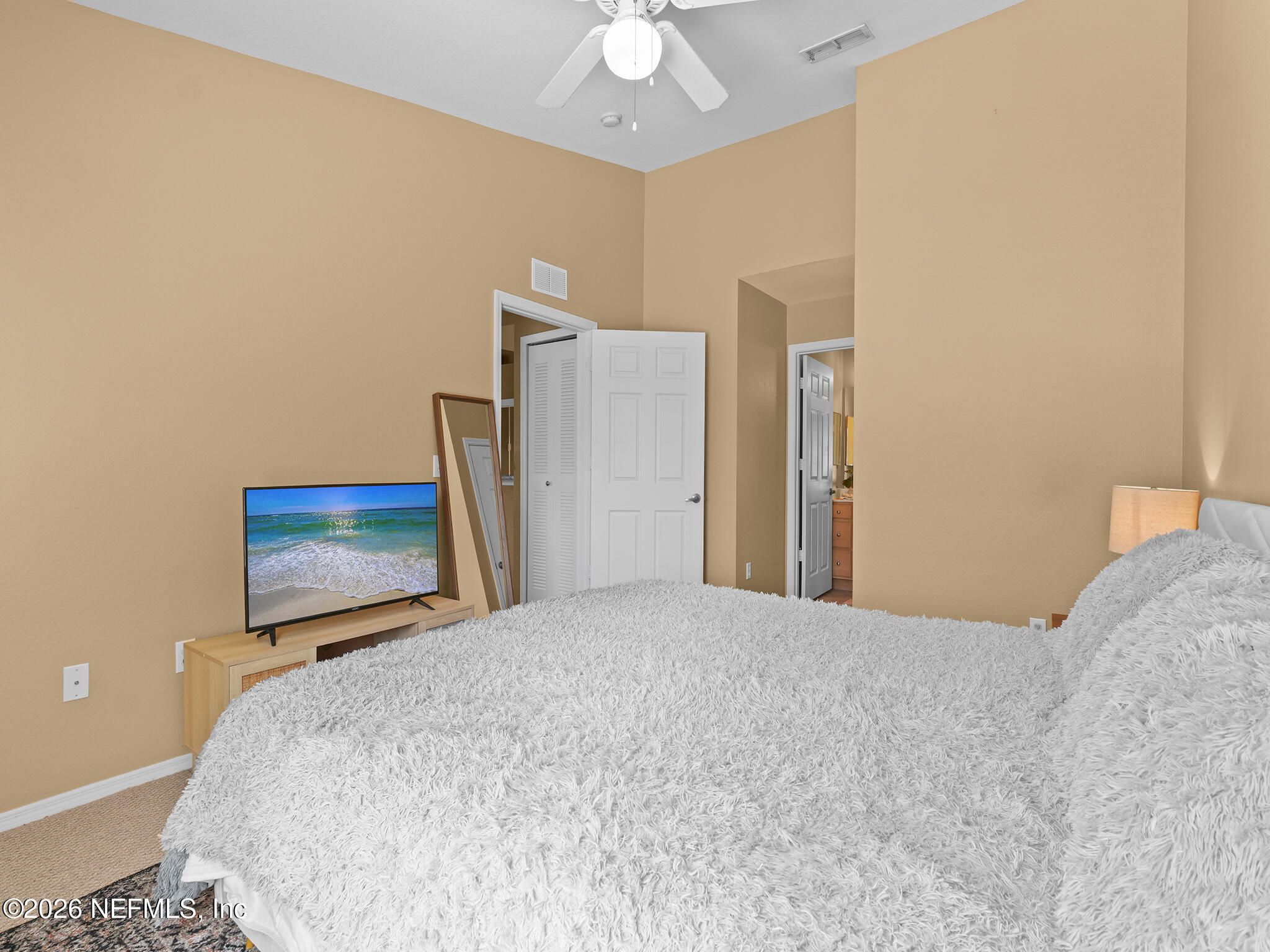 712 Lighthouse Road, Unit 712 Panama City Beach, FL 32407 - Photo 35 of 42 a bedroom with a bed and a chandelier