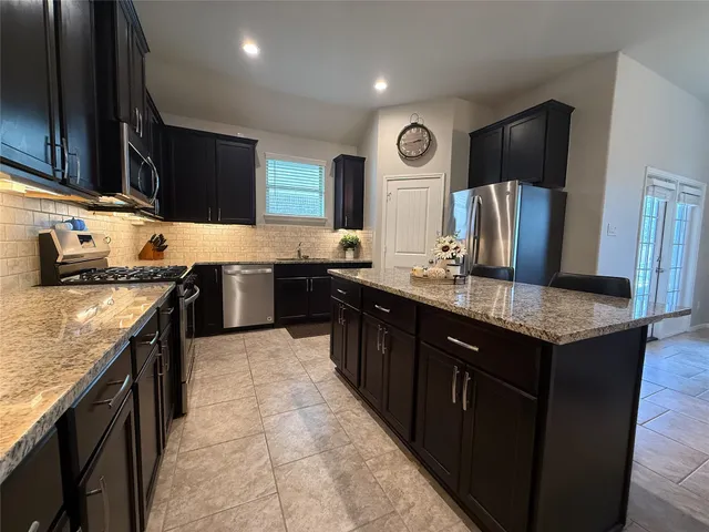 a kitchen with stainless steel appliances granite countertop wooden cabinets a sink and dishwasher