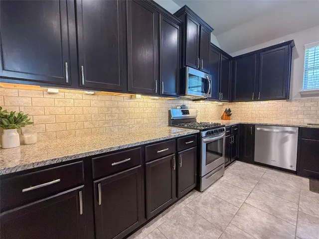 a kitchen with granite countertop wood cabinets and a sink