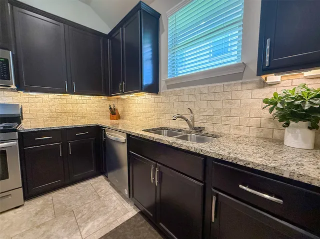 a bathroom with a granite countertop sink a toilet a mirror and shower