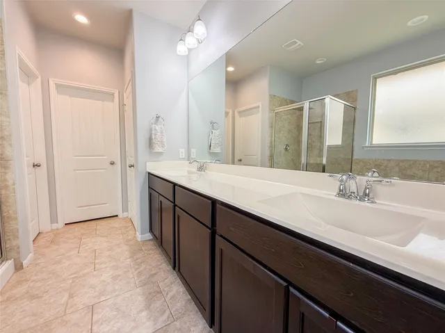a spacious bathroom with a tub sink shower and mirror