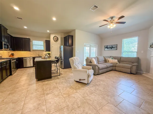 a living room with furniture a flat screen tv and a window