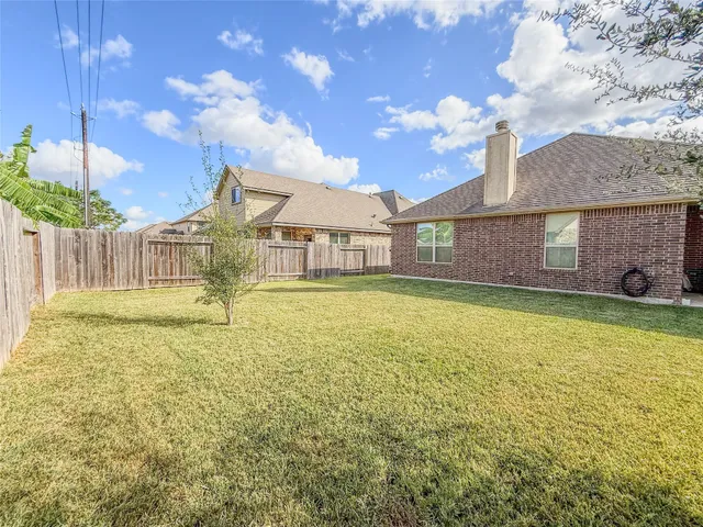 a view of backyard with a chair and potted plants