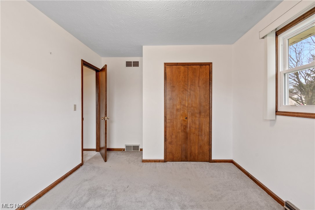 41 Willard Street Rittman, OH 44270 - Photo 15 of 25 Unfurnished bedroom featuring light colored carpet, a textured ceiling, and a closet