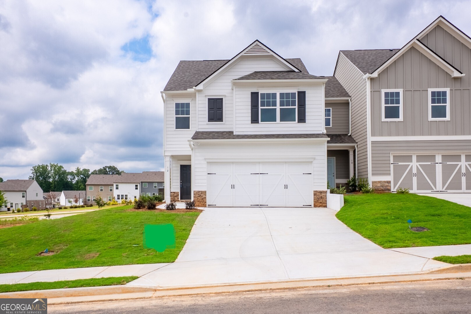 a front view of a house with a yard and garage