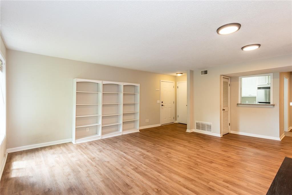 591 Emory Oaks Way, Unit 591 Decatur, GA 30033 - Photo 11 of 33 an empty room with wooden floor and closet