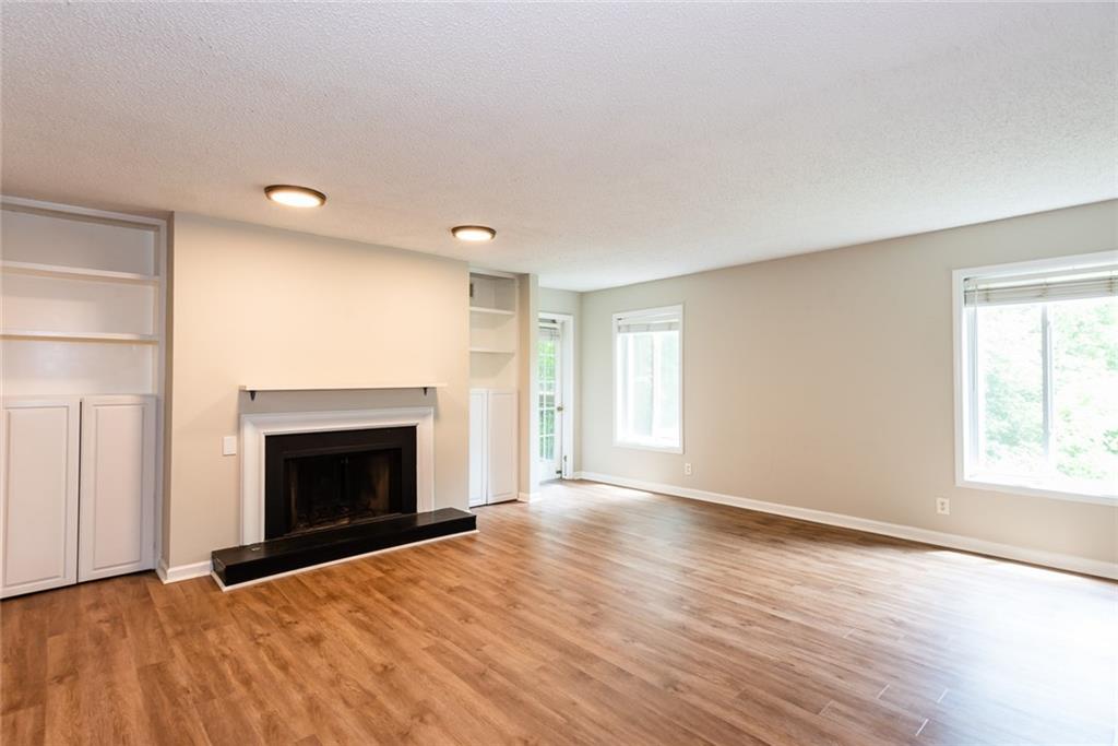 591 Emory Oaks Way, Unit 591 Decatur, GA 30033 - Photo 13 of 33 an empty room with wooden floor fireplace and windows