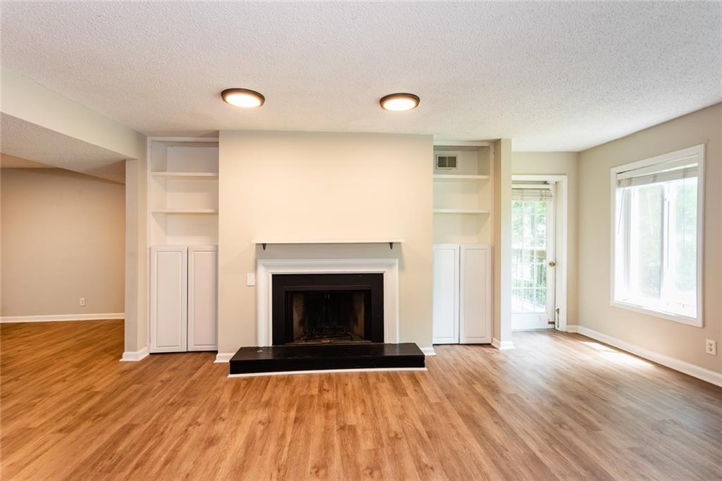 591 Emory Oaks Way, Unit 591 Decatur, GA 30033 - Photo 14 of 33 an empty room with wooden floor fireplace and windows