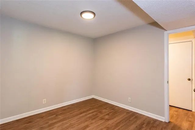 an empty room with wooden floor and closet
