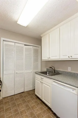 a kitchen with stainless steel appliances granite countertop white cabinets and a stove a oven with white countertops