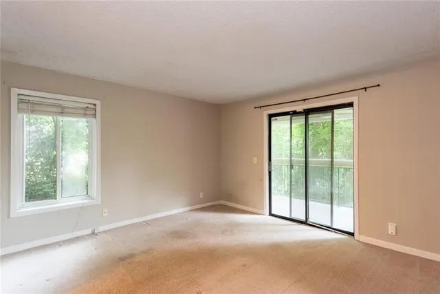 an empty room with windows and closet