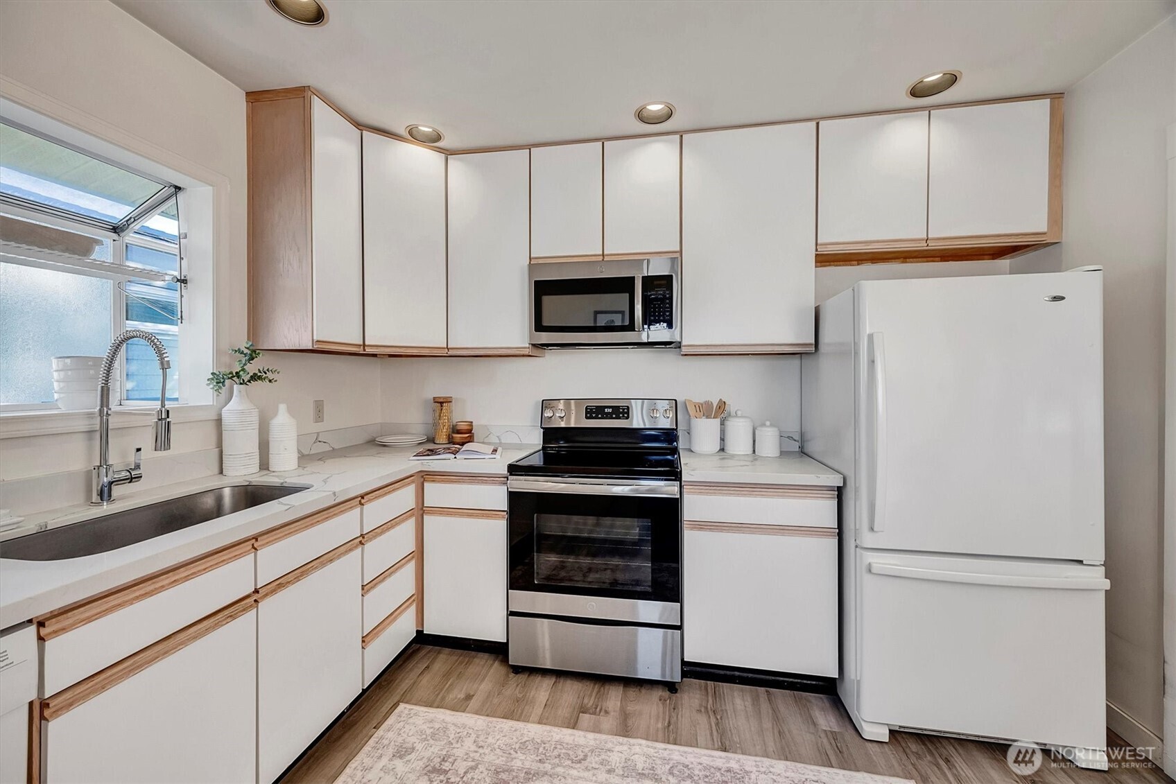 6021 45th Avenue Southwest Seattle, WA 98136 - Photo 8 of 18 a kitchen with granite countertop white cabinets and white appliances
