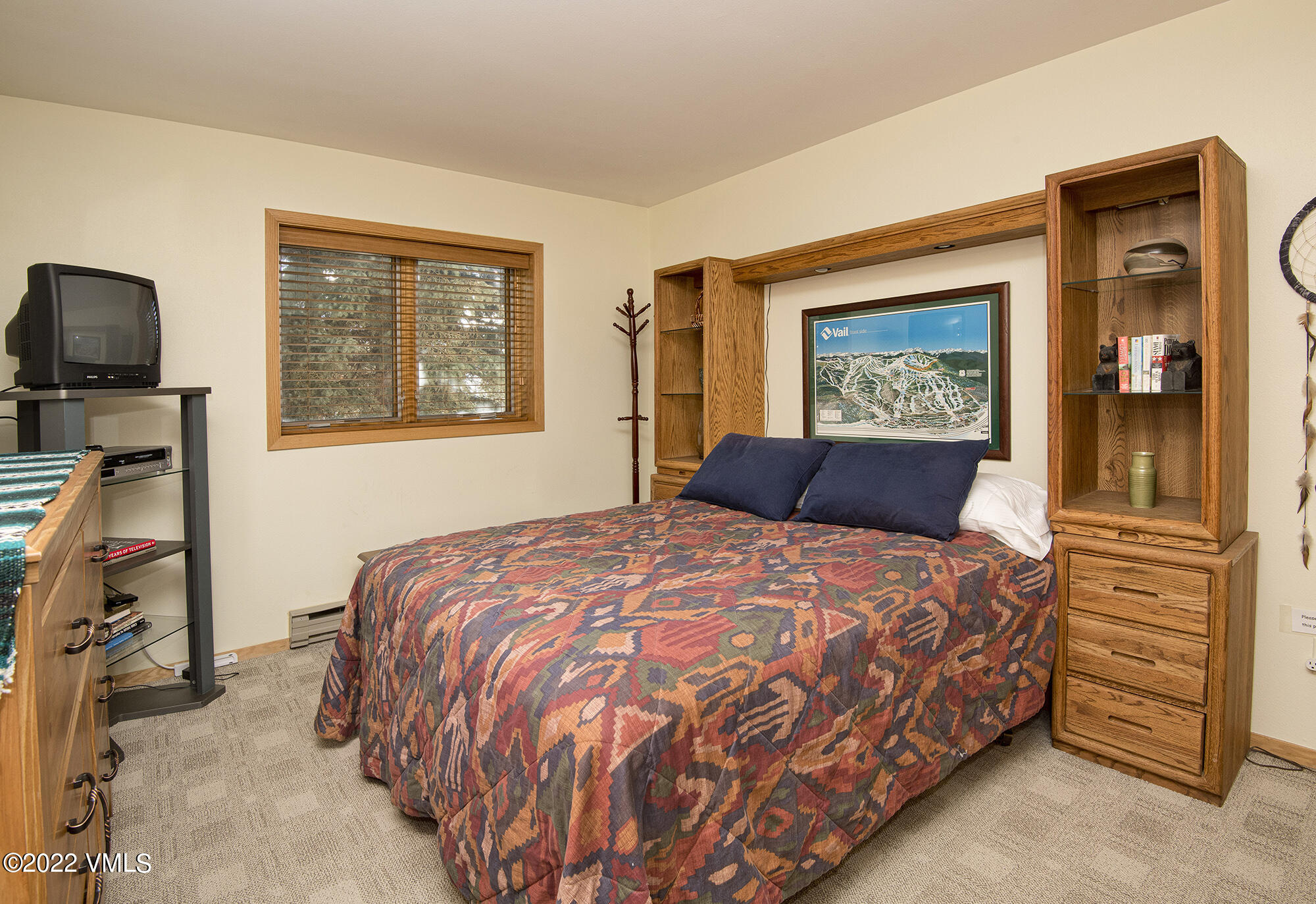 1030 Lions Ridge Loop, Unit 201 Vail, CO 81657 - Photo 16 of 29 a bedroom with a bed and dresser with mirror