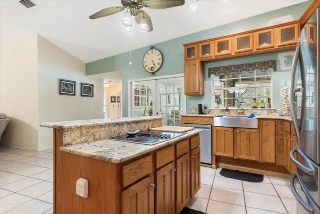 a kitchen with stainless steel appliances granite countertop a refrigerator a sink dishwasher and a stove with wooden floor