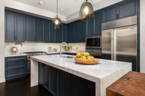 a kitchen with stainless steel appliances a sink a stove and a refrigerator