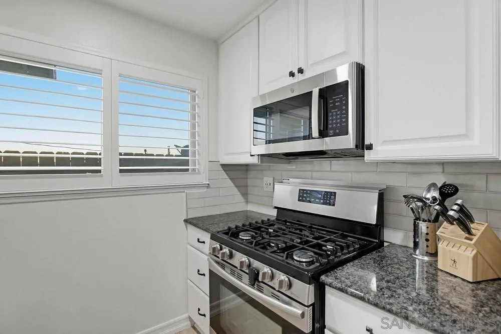 11038 Larkridge Street Santee, CA 92071 - Photo 12 of 44 a kitchen with stainless steel appliances a stove a microwave and cabinets