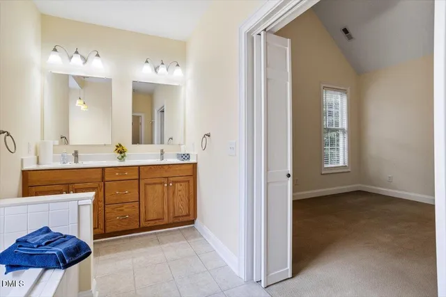 a bathroom with a tub sink and mirror