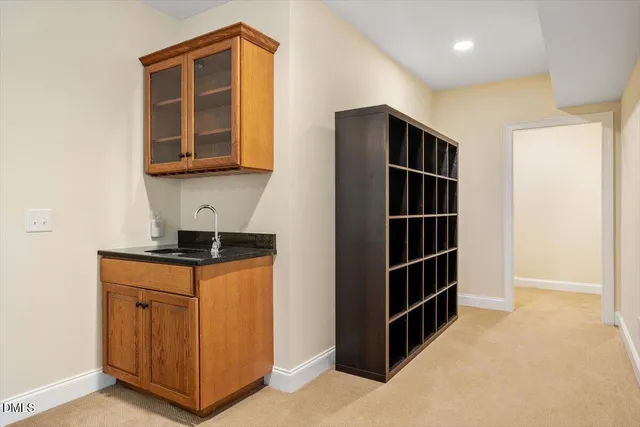 a view of an empty room with a kitchen and window