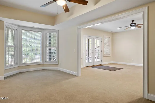 an empty room with mirror and windows