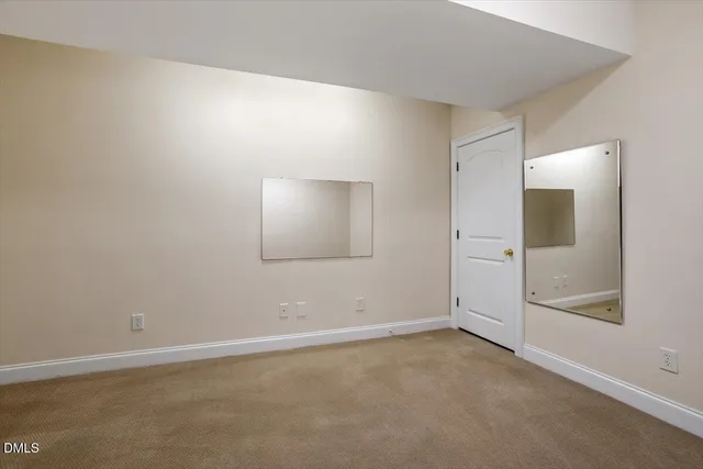 an empty room with a chandelier fan and windows