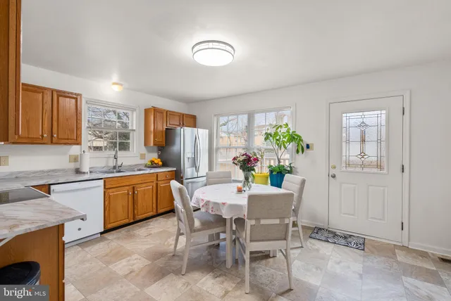 a dining room filled chandelier and kitchen view