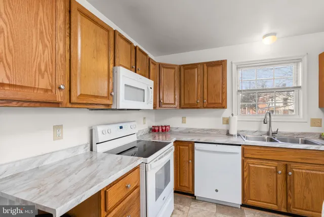 a kitchen with stainless steel appliances granite countertop a sink a stove and cabinets