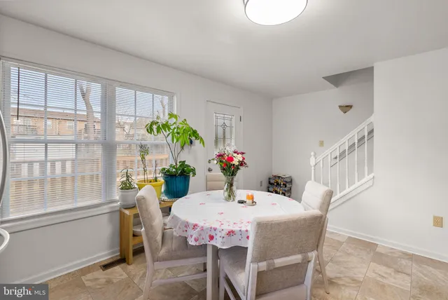 a dining room with furniture potted plants and wooden floor