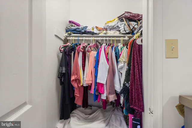a view of walk in closet with clothes