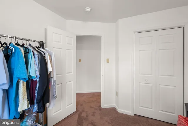 a view of walk in closet with clothes
