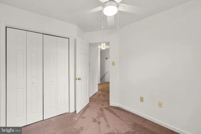 an empty room with a fan and a chandelier fan