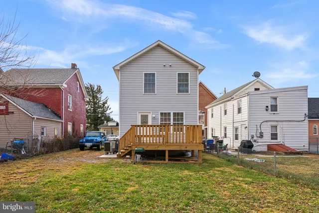 a view of a house with a yard and deck area