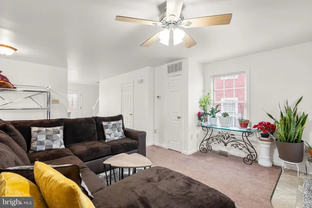 a living room with furniture and a potted plant