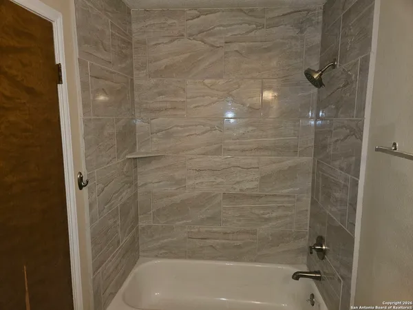 a bathroom with a shower and a bath tub