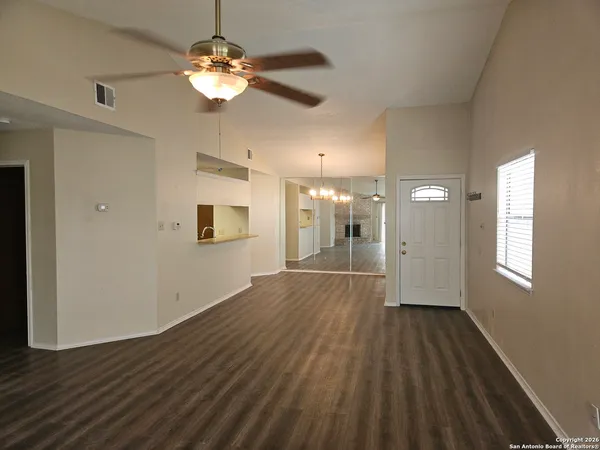 a view of a room with wooden floor and a ceiling fan