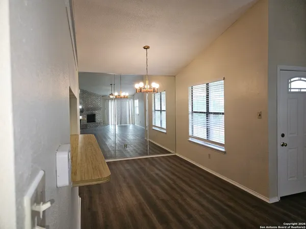 a view of a room with wooden floor chandelier and entryway