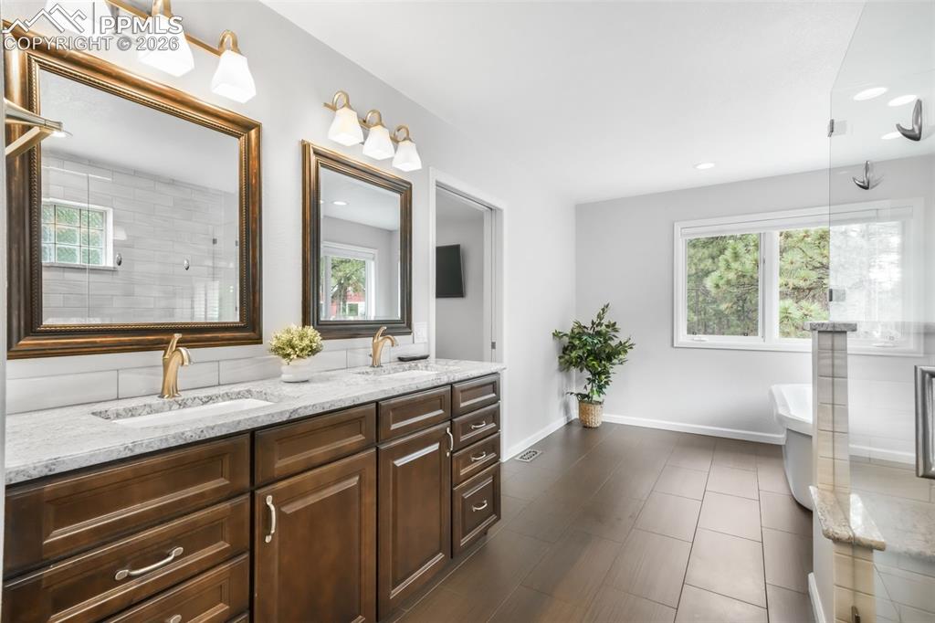 19010 Deerfield Road Monument, CO 80132 - Photo 25 of 50 a spacious bathroom with a granite countertop sink and a large mirror