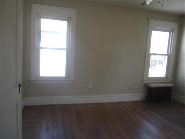 104 Fenwick Street Springfield, MA 01109 - Photo 9 of 12 an empty room with wooden floor and windows