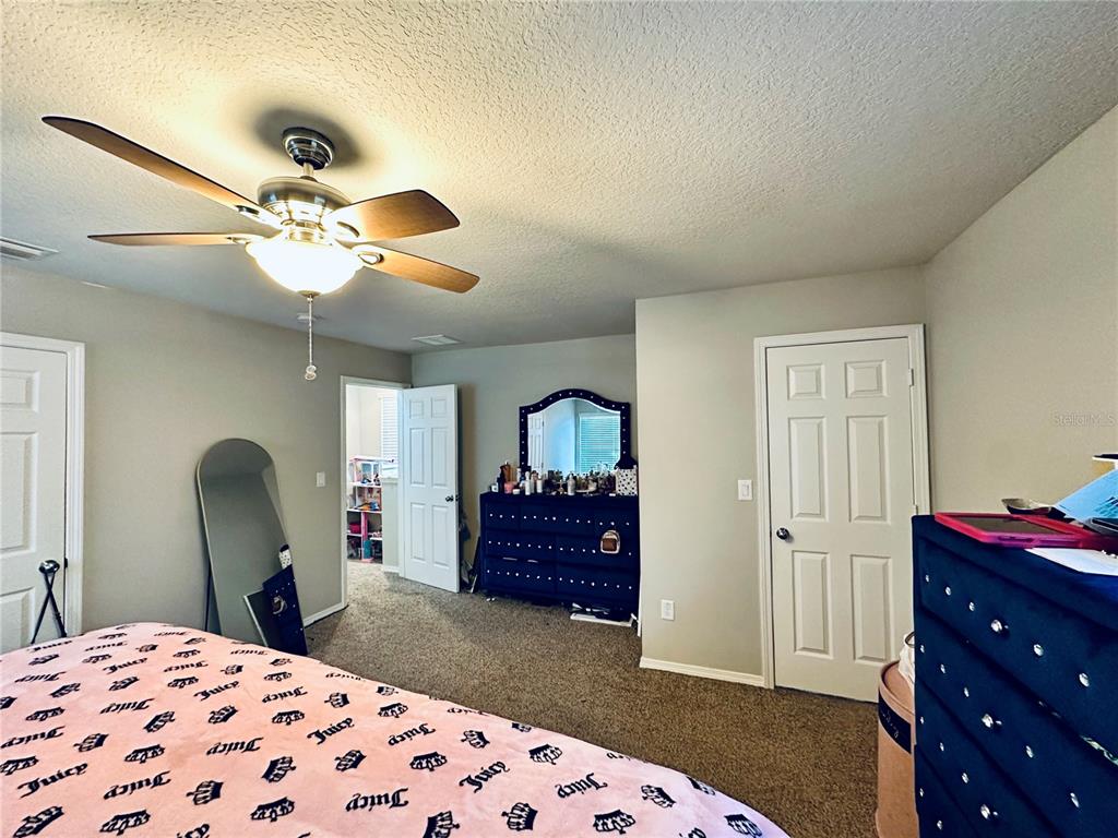 4411 Banyan Tree Place Riverview, FL 33578 - Photo 14 of 27 a bedroom with a bed and a chandelier