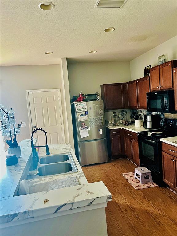 4411 Banyan Tree Place Riverview, FL 33578 - Photo 8 of 27 a kitchen with stainless steel appliances wooden cabinets sink and stove