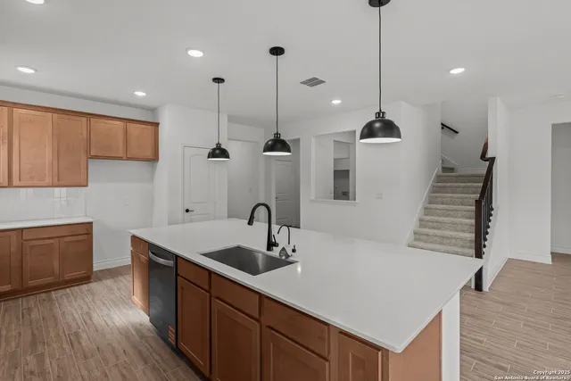 a kitchen with stainless steel appliances granite countertop a sink a oven a refrigerator and a stove