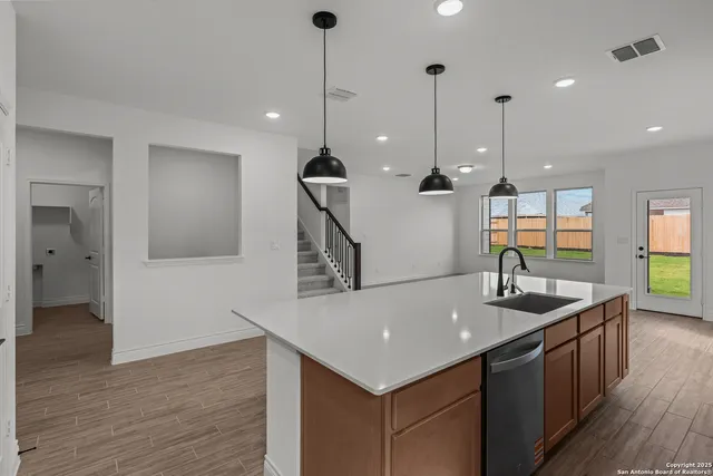a kitchen with kitchen island a sink appliances and a counter top space