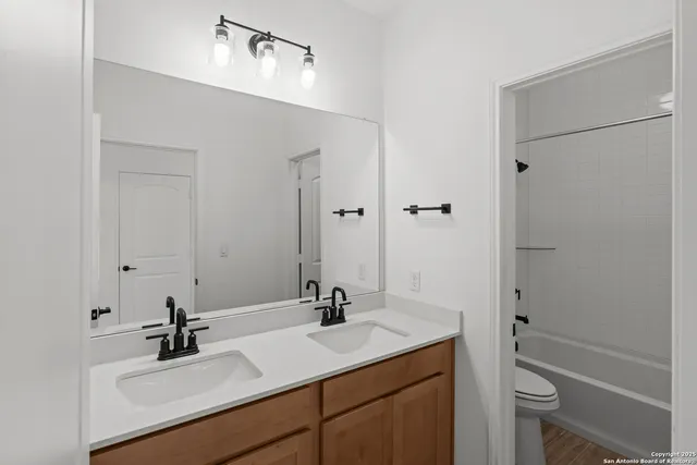 a bathroom with a sink vanity granite tub and shower
