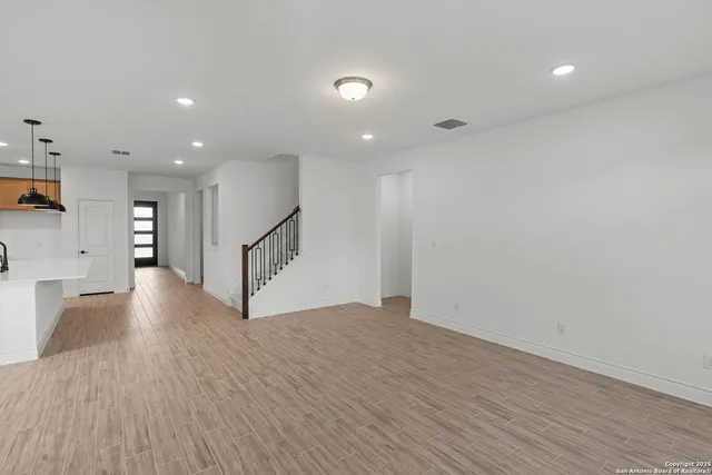 a view of an empty room with wooden floor