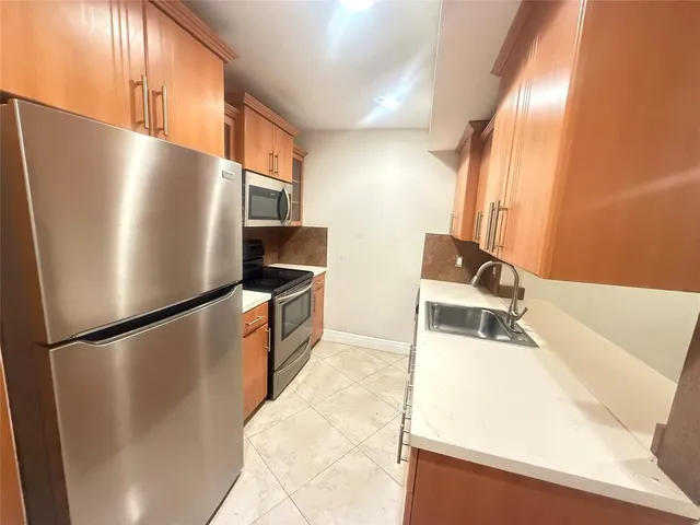 a kitchen with stainless steel appliances refrigerator and microwave