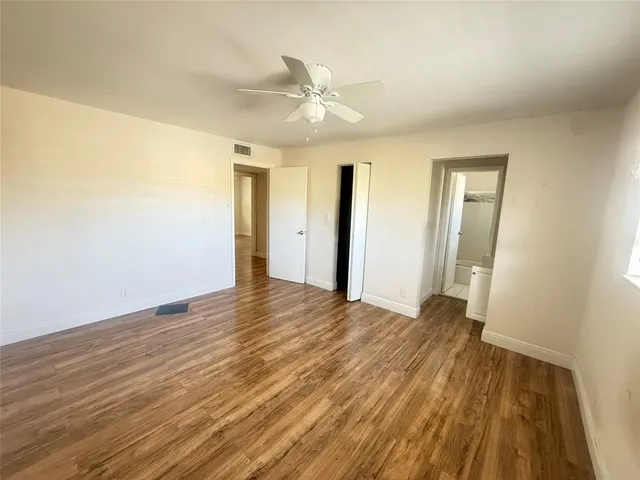 a view of a livingroom with wooden floor and a ceiling fan