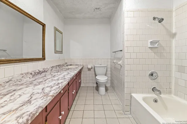 an empty room with a chandelier fan and windows